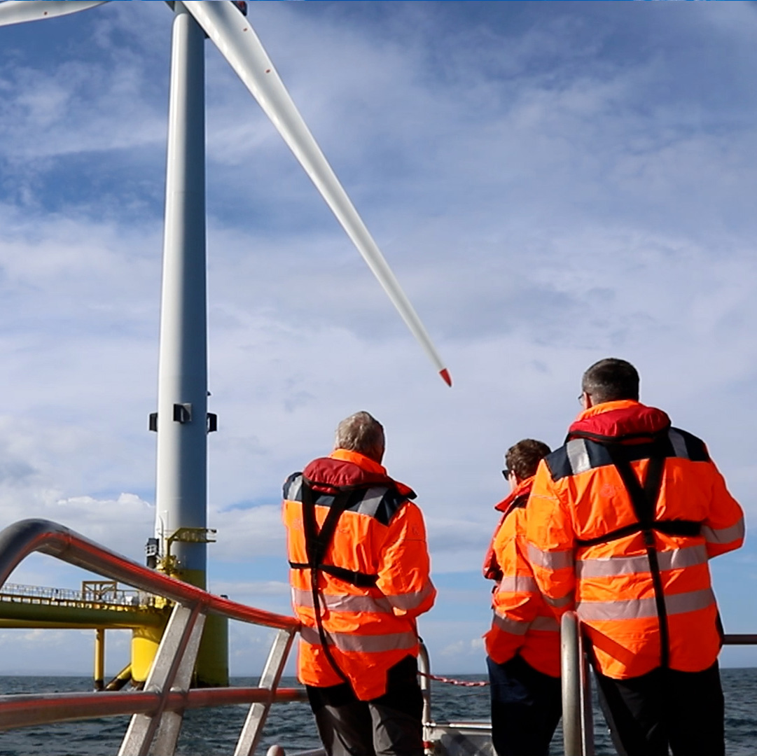 image of workers at sea near wind turbine